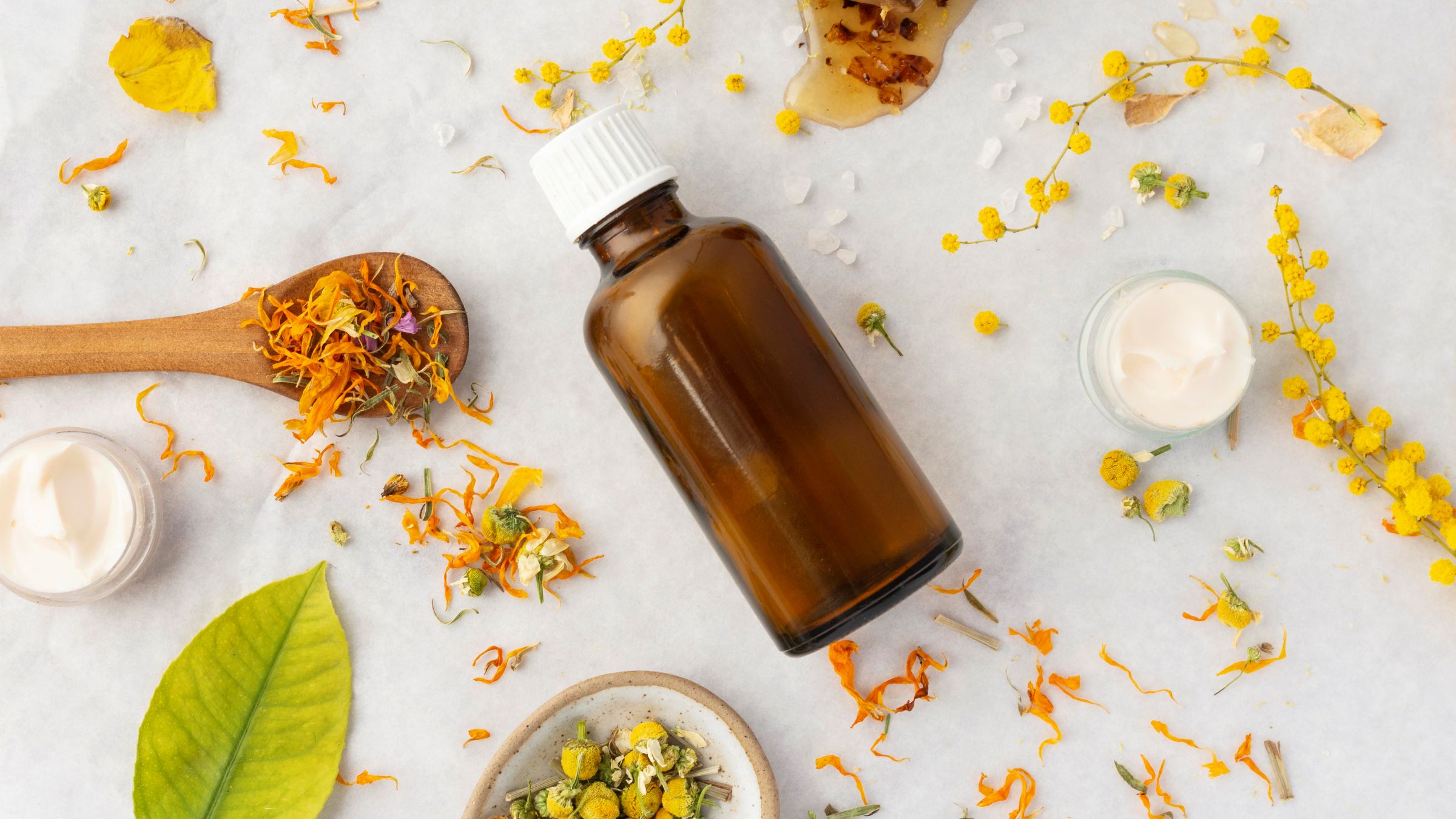 olejek eteryczny do sauny na tle suszonych ziół i kwiatów